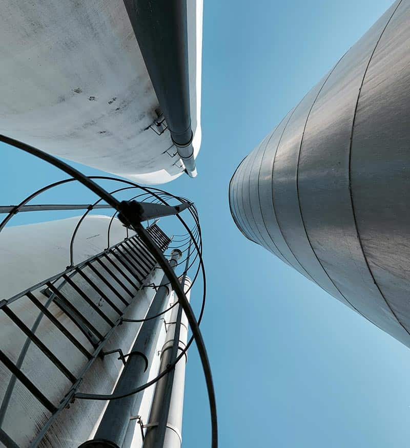 Industrial Metal Towers Torre de almacenamiento industrial vista desde abajo, infraestructura moderna y eficiente.