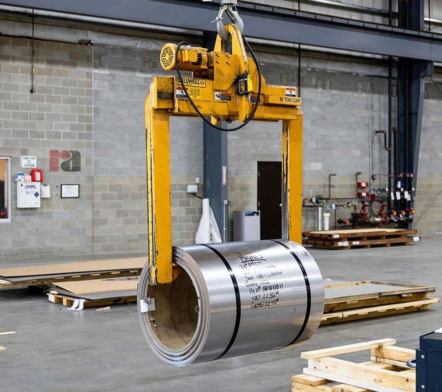 Crane inside Factory Maquinaria industrial de manipulación de bobinas de acero en un almacén de Tecnotray, especializada en soluciones para el sector metalúrgico.