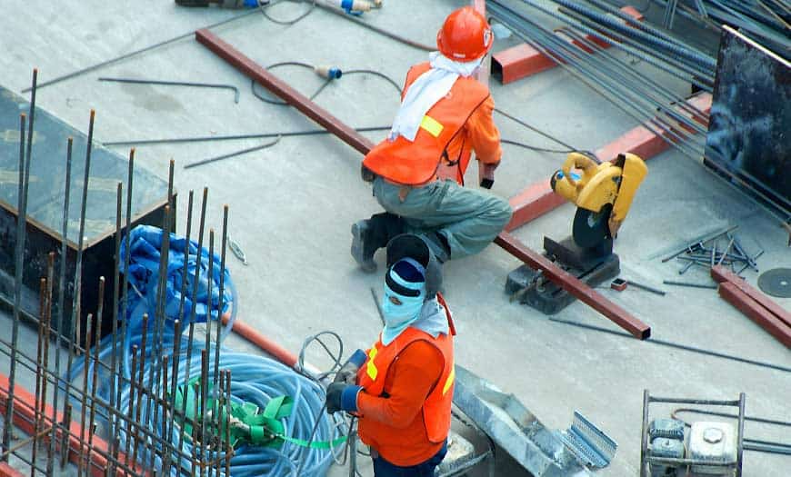Two Men Working in a Factory Soldadores de construcción en oficina técnica especializada en proyectos estructurales.