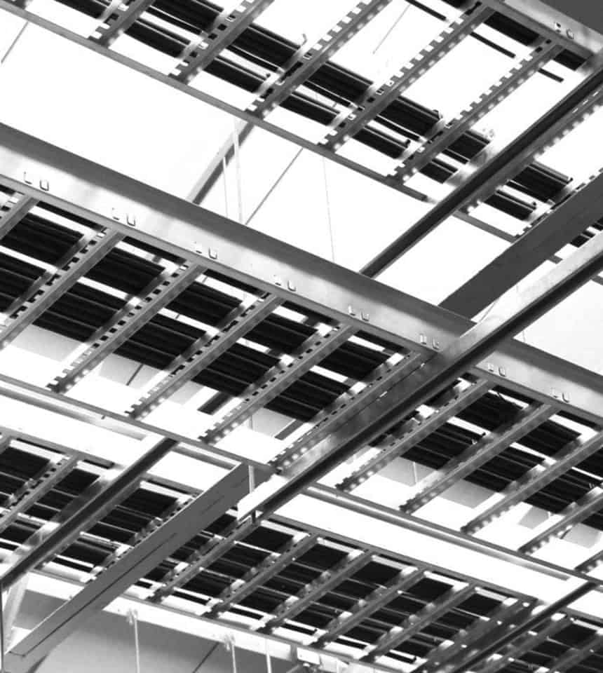 Estructura metálica industrial en construcción, vista en blanco y negro.