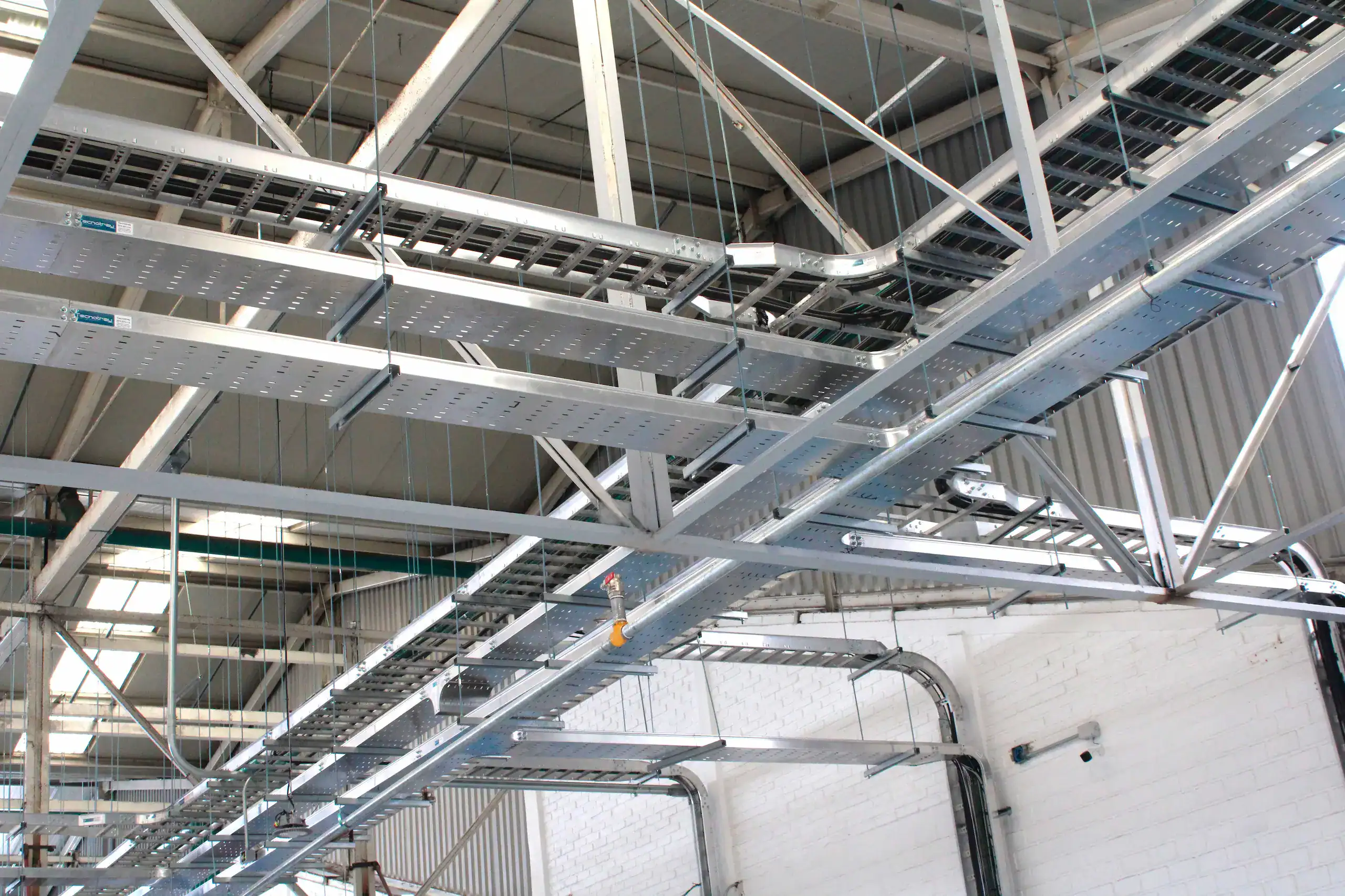 Instalación de charolas portacables metálicas de Tecnotray para canalización y organización del cableado eléctrico en proyectos industriales como el Metro de la CDMX.