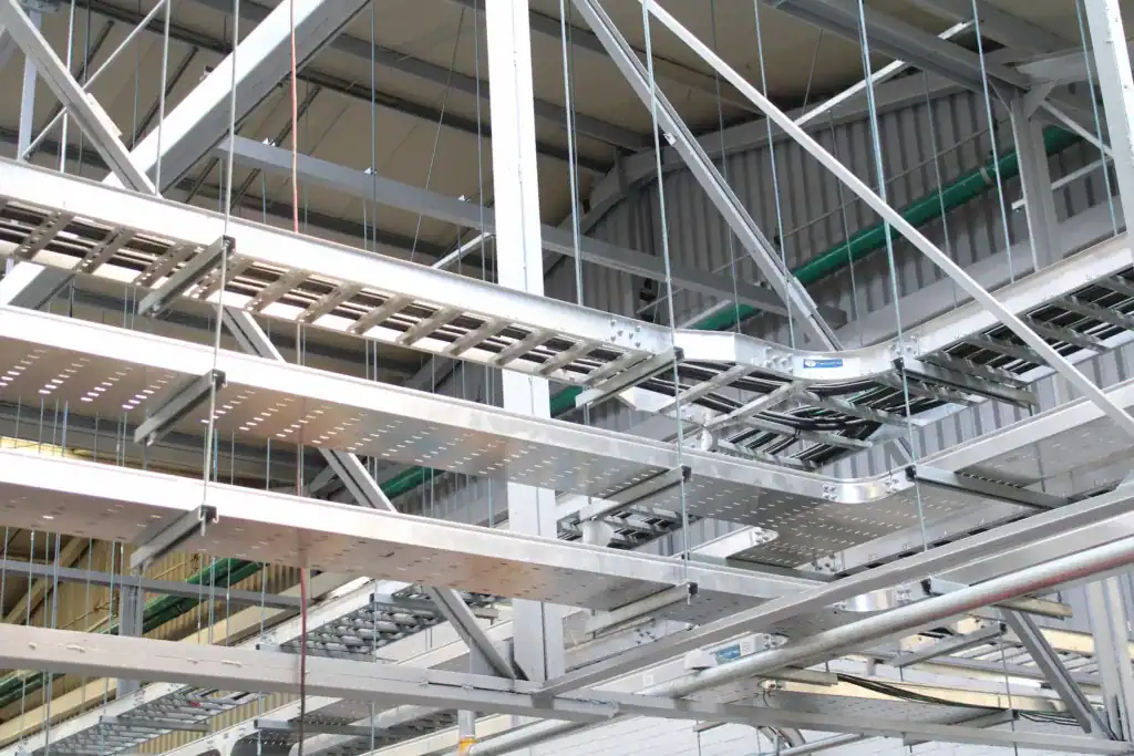 charolas-y-canalizaciones Vista de diferentes tipos de instalaciones eléctricas en una planta industrial, con charolas metálicas y sistemas de canalización.